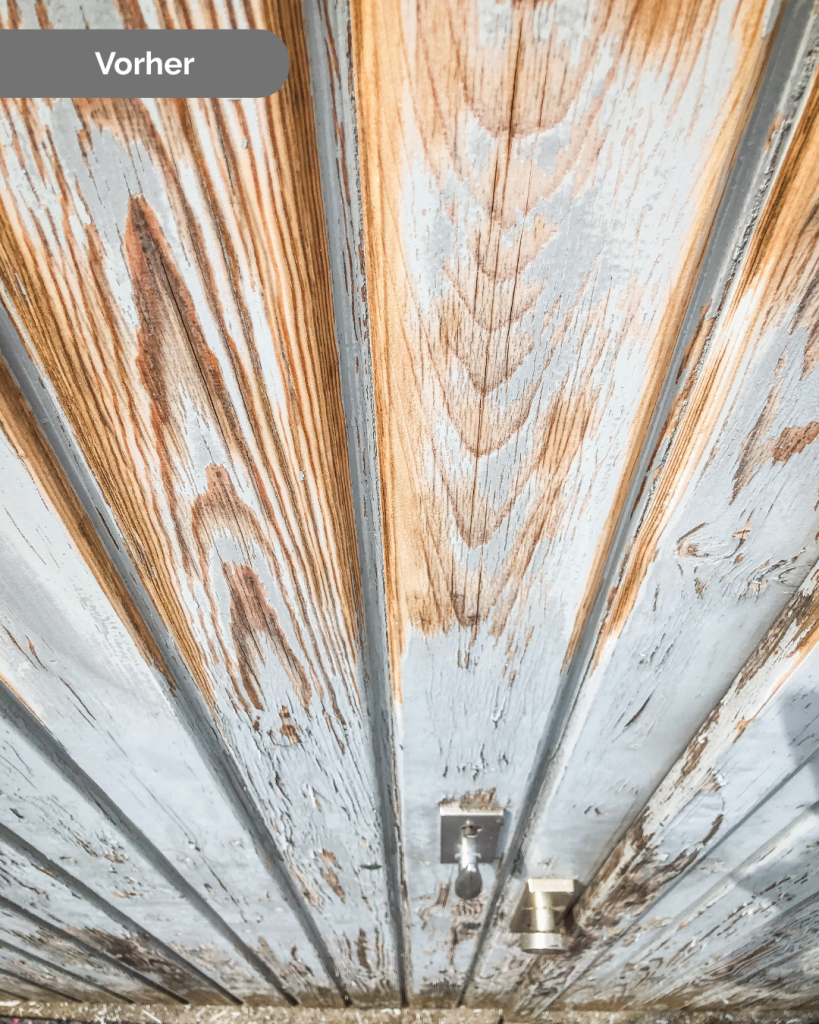 Detailaufnahme einer verwitterten Holztür mit abgeblätterter Farbe vor der Renovierung