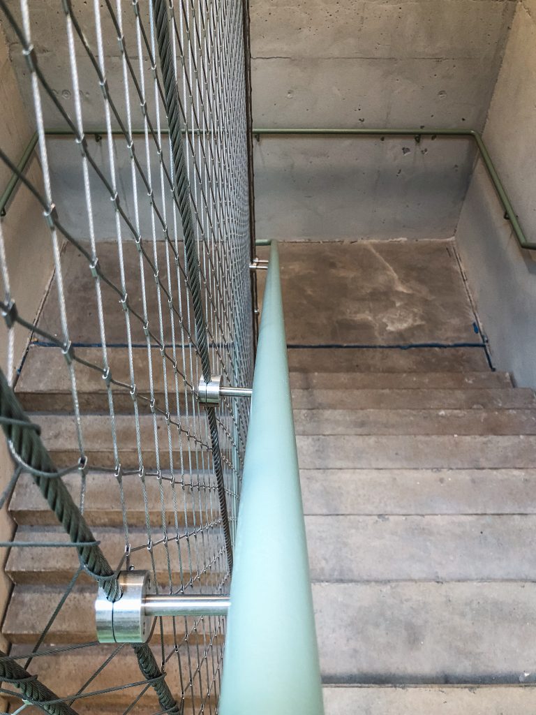 Treppenhaus vor der Renovierung mit abgenutzten Betonstufen und altem Geländer
