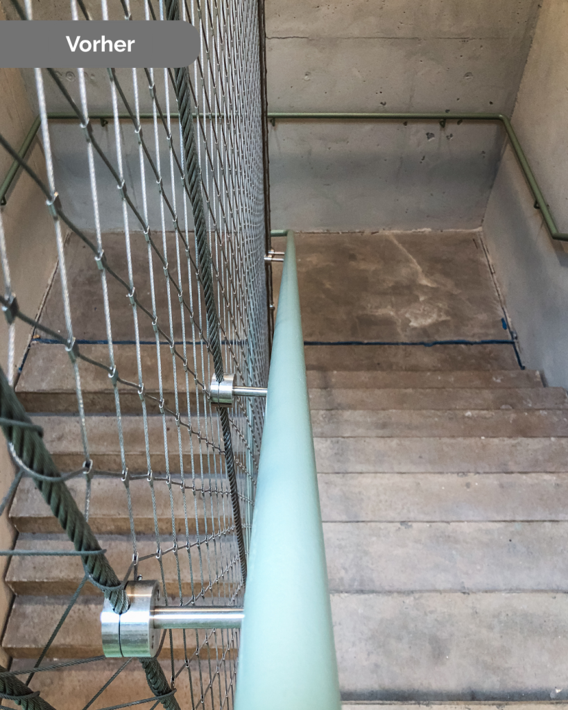 Treppenhaus vor der Renovierung mit abgenutzten Betonstufen und altem Geländer